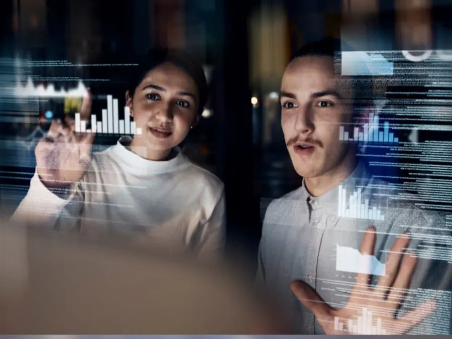 Two colleagues studying data on a transparent screen