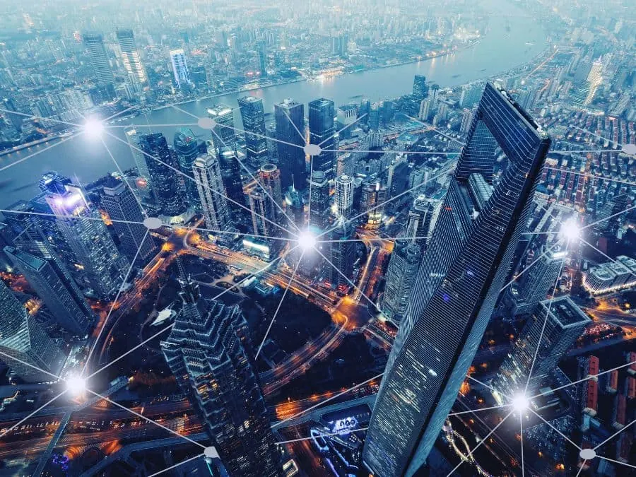 A city at night with glowing network lines connecting its buildings